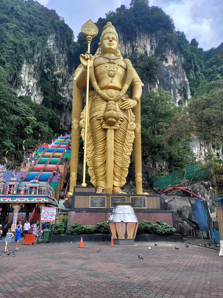 Lord Murugan - gouden standbeeld naast de gekleurde trappen van de Batu Caves